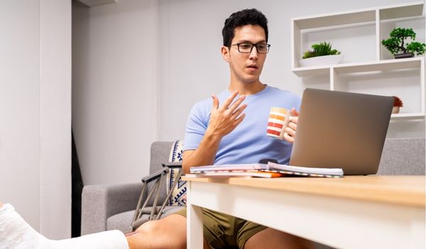 Injured worker at home talking to employer through a virtual meeting